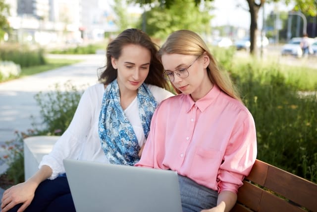 ノートパソコンを見ている二人の女性